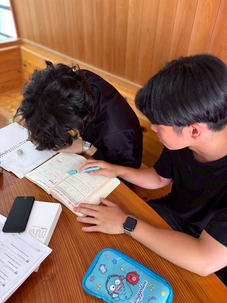 講師が生徒の教材を見ながら1対1で指導する様子